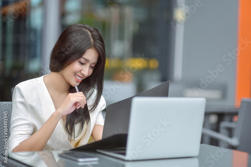 Young woman sitting in a cafe with her laptop, Stressful for work.