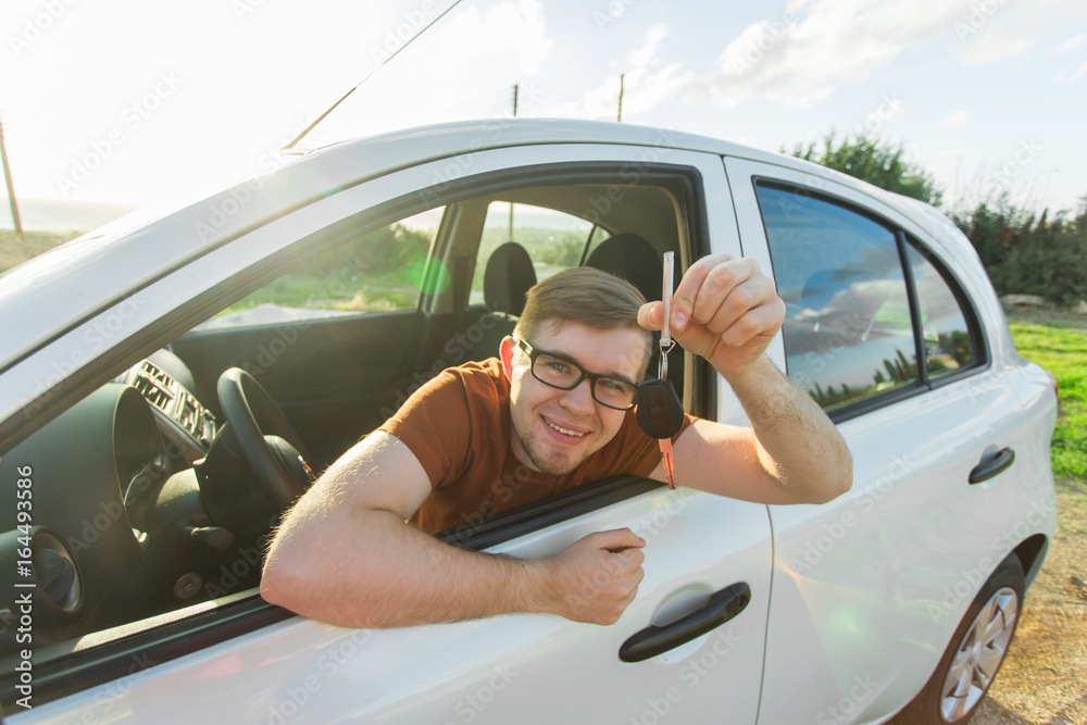 Naklejka premium Happy man showing the key of his new car