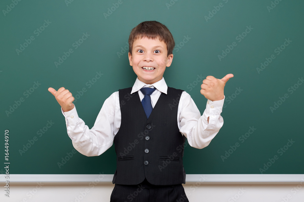 Schoolboy posing at school board, empty space, education concept Schoolboy posing at school board, empty space, education concept