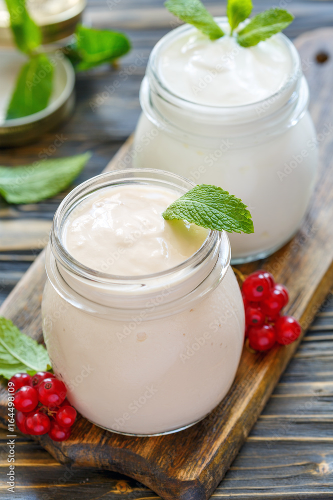 Sour baked milk and natural yoghurt in glass jars.