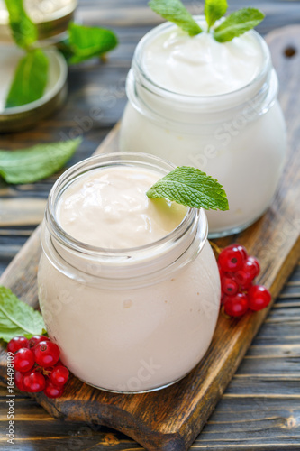 Sour baked milk and natural yoghurt in glass jars.