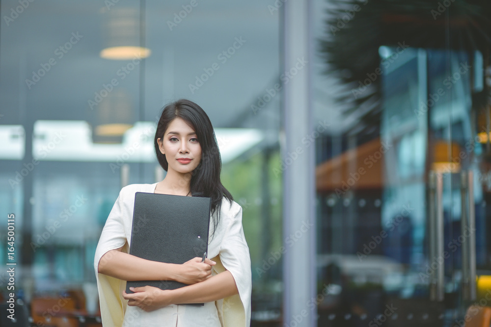 Young pretty business woman with laptop in the office, smiling pretty young business woman in glasses sitting on workplace. Selective focus