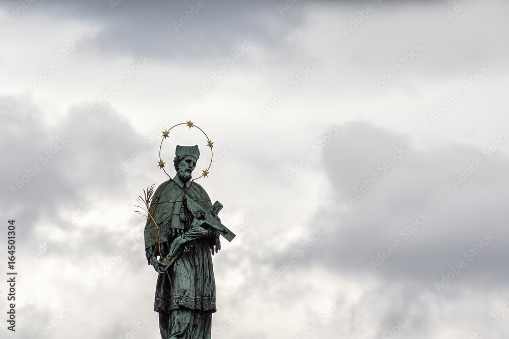 Historic religious statue against dramatic sky