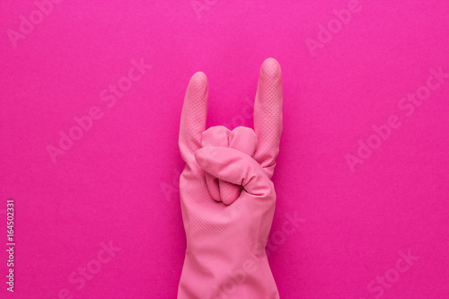 hand in pink protective glove shows horns gesture. cool cleaning service concept