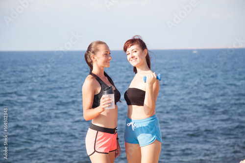two girls after sports and fitness on the beach photo