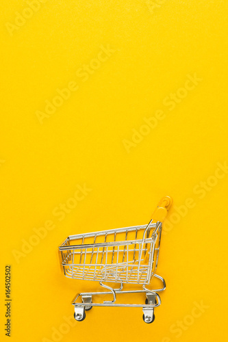 shopping trolley on yellow background with some copy space