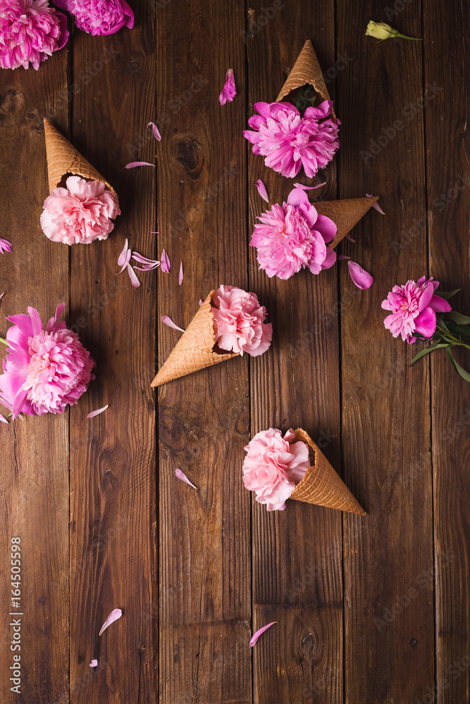 Flowers in a waffle cone. Pink carnations. Flowers on a wooden background. Copyspace. Flower photo concept Flowers in a waffle cone. Pink carnations. Flowers on a wooden background. Copyspace. Flower photo concept