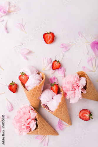 Ice cream in a waffle cone on a light background. Strawberry ice cream. Flowers in a waffle cone. Pink carnations. Flowers on a wooden background. Copyspace. Flower photo concept.