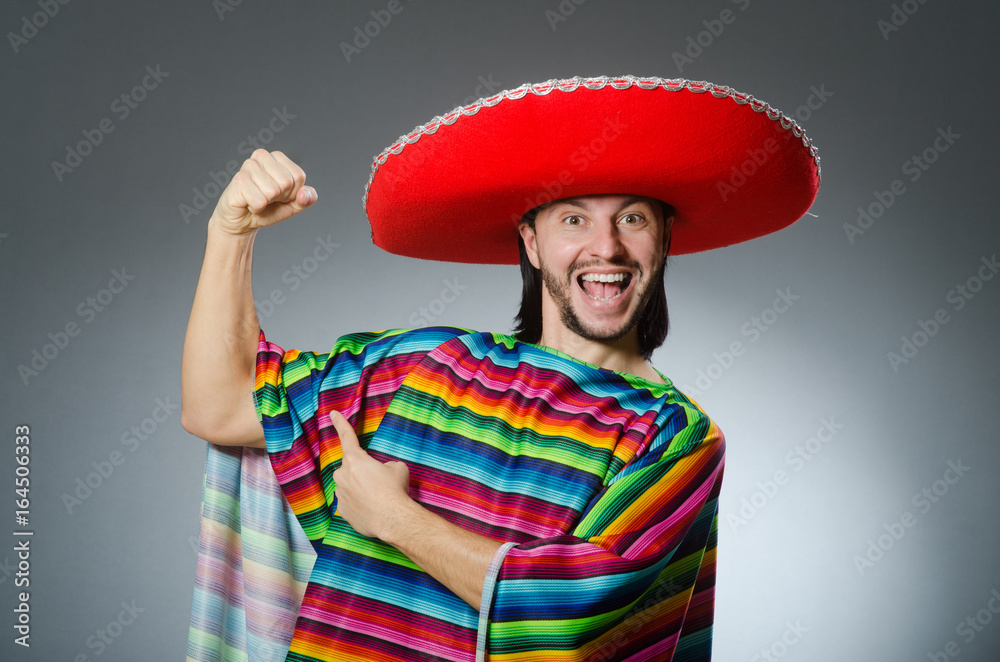 Man in a vivid mexican poncho gray background isolated Man in a vivid mexican poncho gray background isolated