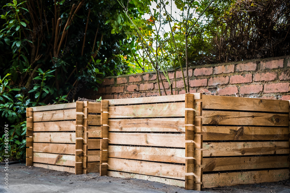 Two wooden compost bins in a back garden. Two wooden compost bins in a back garden.