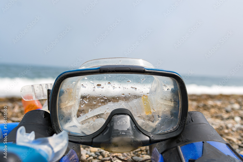 Mask and fins of a diver on the seashore