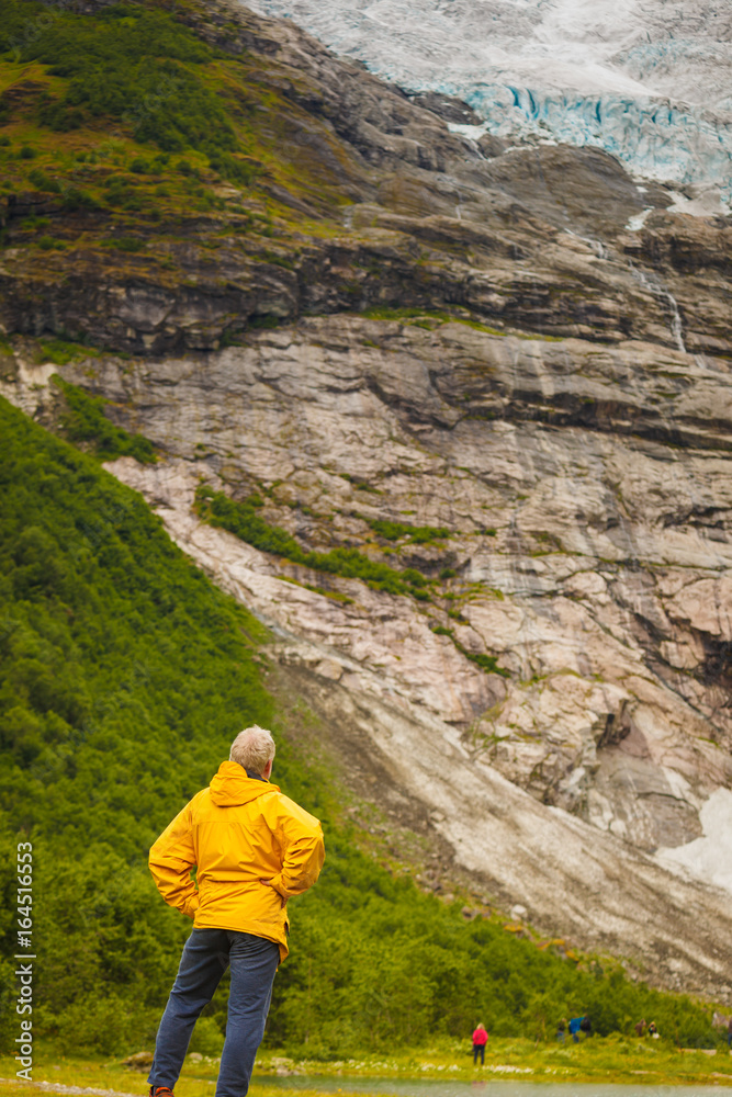 Tourist admiring Boyabreen Glacier in Norway