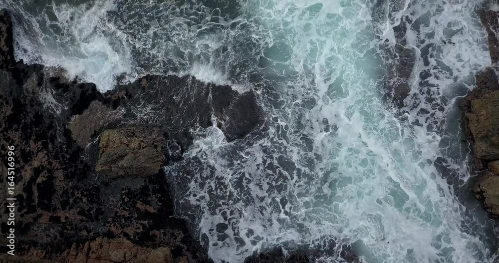 waves crash into rocks on the shore, aerial waves crash into rocks on the shore, aerial