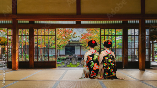 Japanese Geisha Look at a Small Rock Garden at  Kennin-ji Temple in Colorful Autumn
