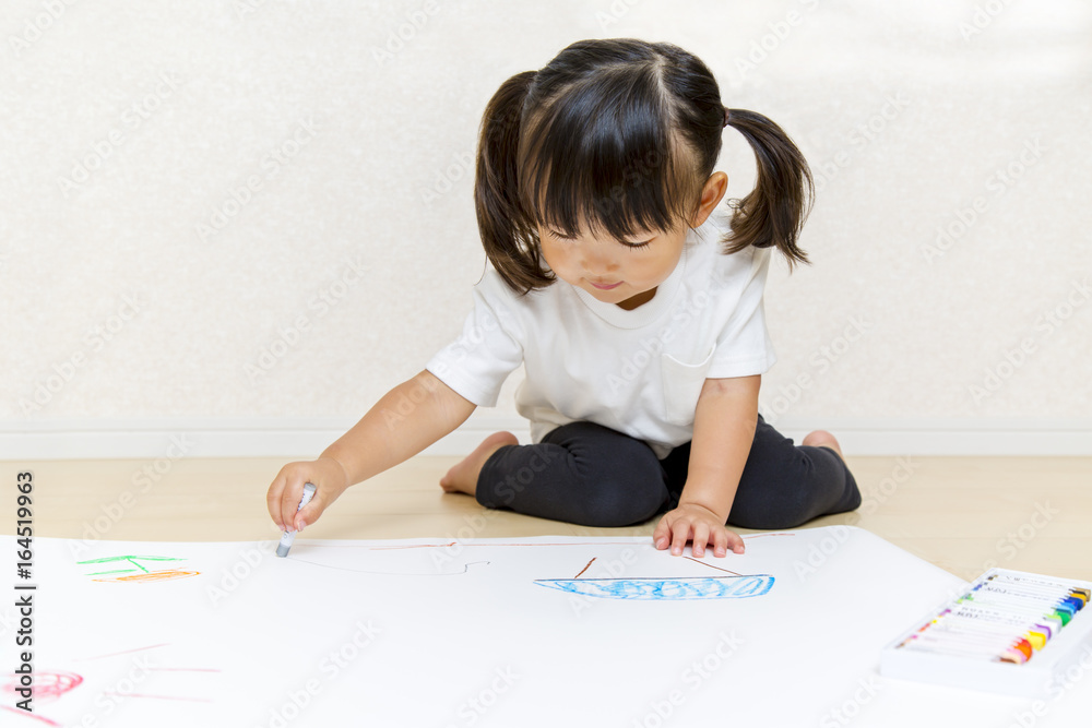 フローリングで絵を描く幼い女の子 フローリングで絵を描く幼い女の子