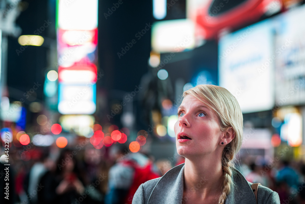 Fototapeta premium Impressed Woman in the Middle of Times Square at Night,