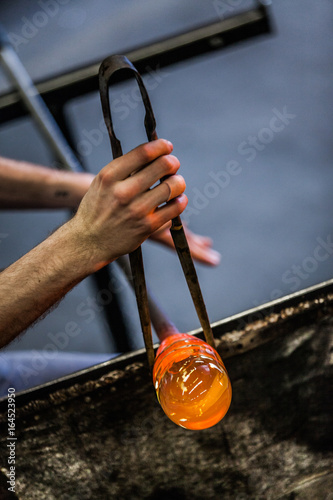 Man Hands Closeup Working on a Blown Glass Piece photo