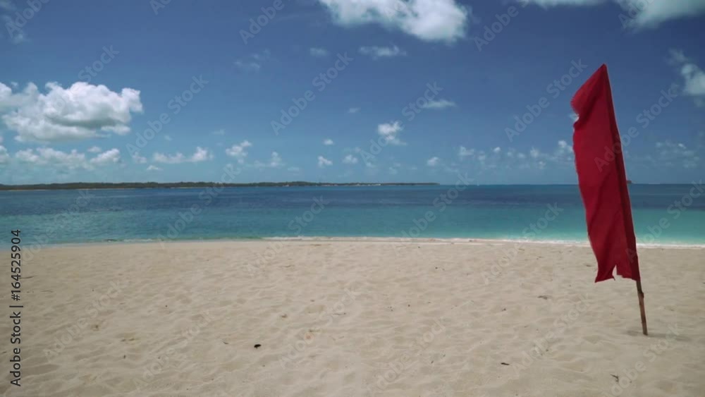 Red flag on white sand beach on tropical island, Philippines Red flag on white sand beach on tropical island, Philippines