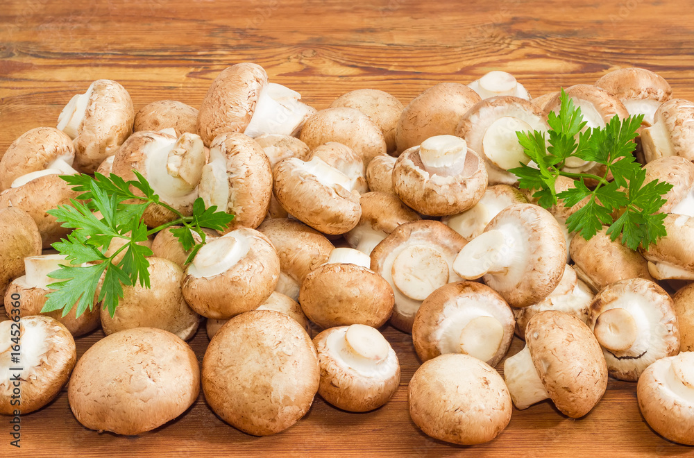 Uncooked edible mushrooms on a wooden surface