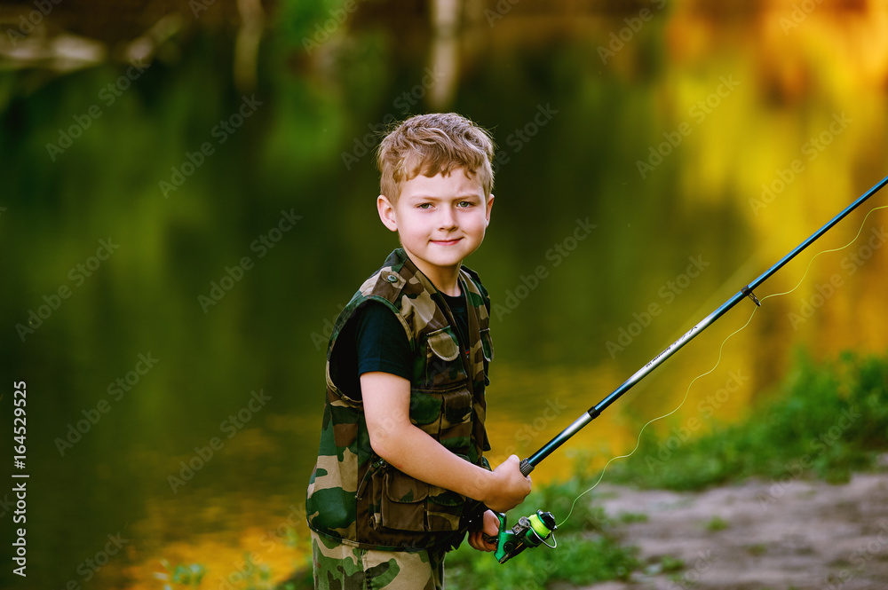 Boy catches fish in the river.The concept of tourism and leisure Boy catches fish in the river.The concept of tourism and leisure