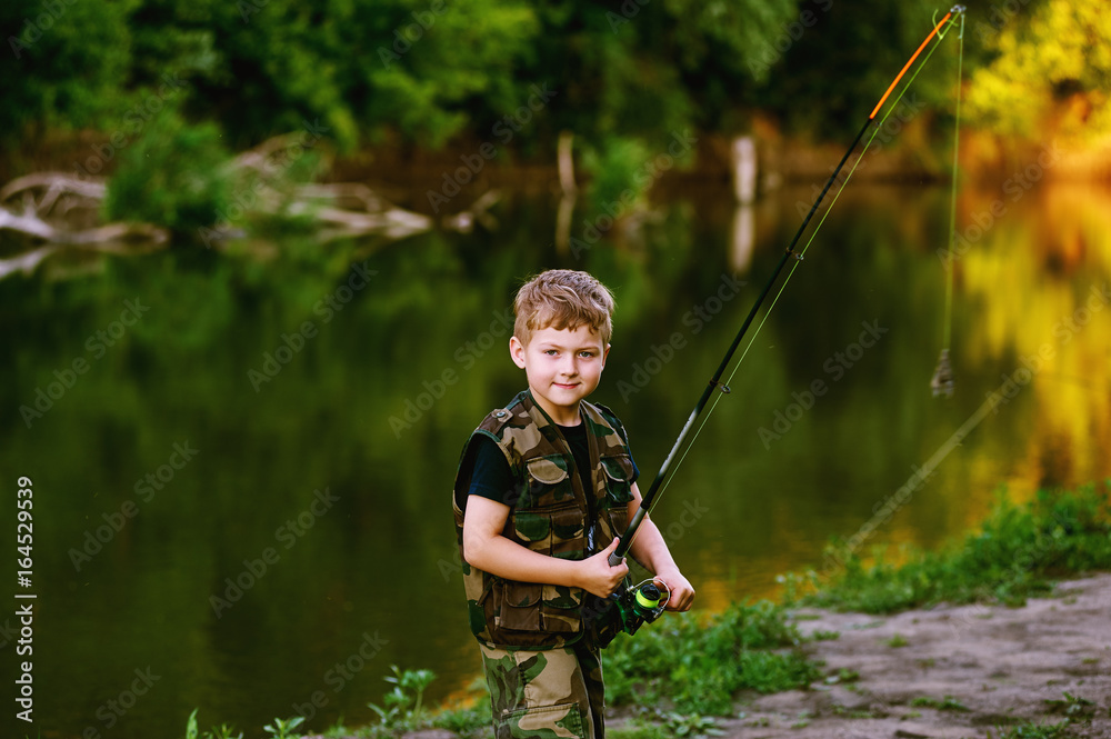 Boy catches fish in the river.The concept of tourism and leisure Boy catches fish in the river.The concept of tourism and leisure