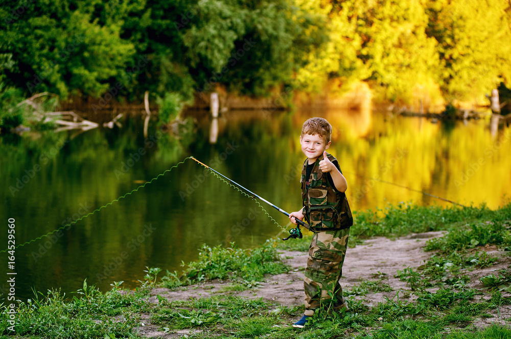Boy catches fish in the river.The concept of tourism and leisure Boy catches fish in the river.The concept of tourism and leisure