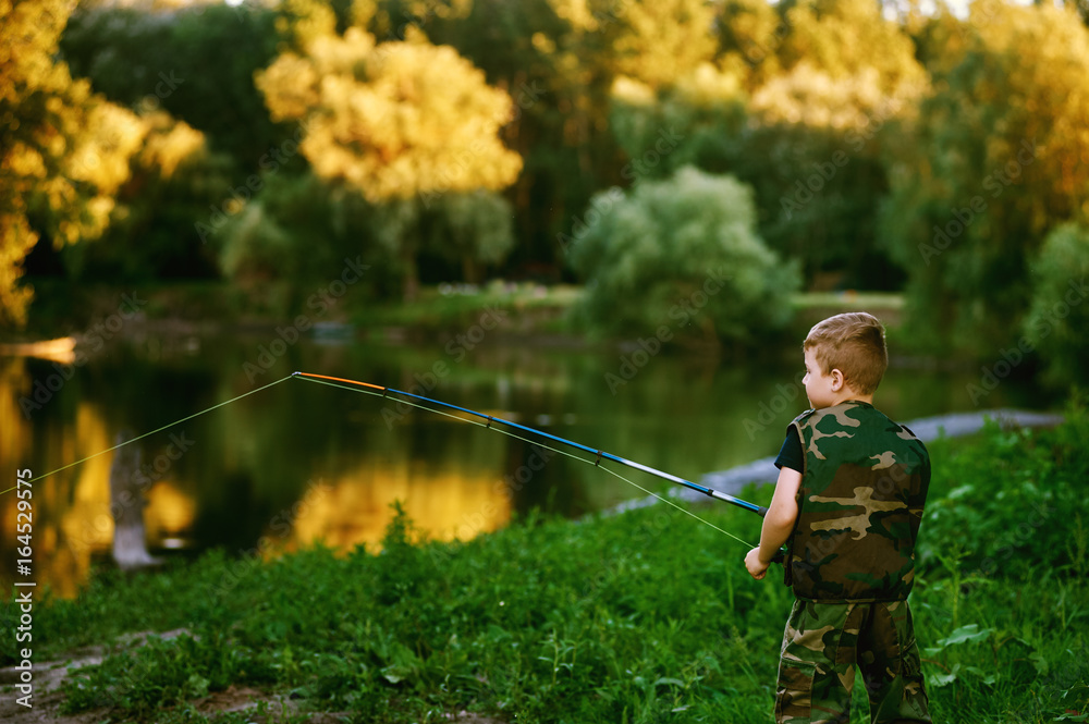 Boy catches fish in the river.The concept of tourism and leisure Boy catches fish in the river.The concept of tourism and leisure