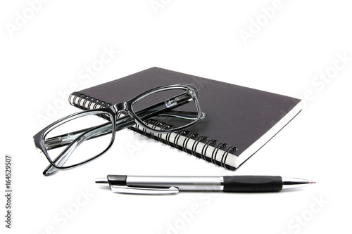 Notebook glasses and pen on white background.