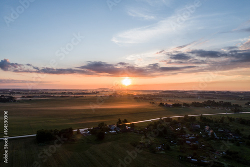 Aerial view of city in fog at amazing sunset. Summer nature landscape.