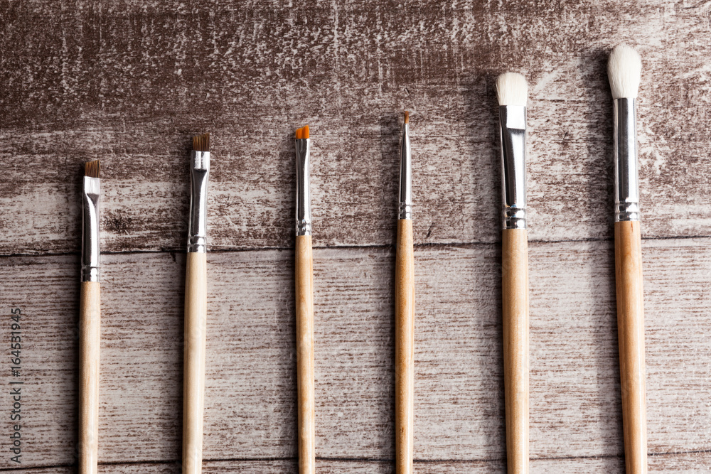 Make up brushes on wooden background in studio photo. Facial care and cosmetics Make up brushes on wooden background in studio photo. Facial care and cosmetics
