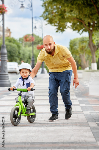 First lessons bicycle riding. Father teach his son to ride a bike.