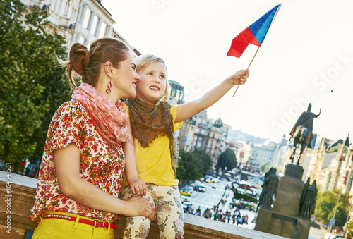 happy mother and daughter tourists in Prague rising flag photo