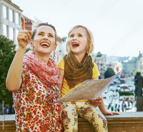 mother and child travellers in Prague holding map and pointing photo