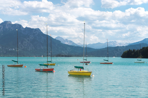 Small calorful sailboats. Beautiful alpine lake and mountains. Bavaria, Germany.
