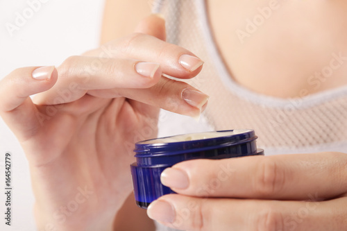 Closeup of female hands applying cream