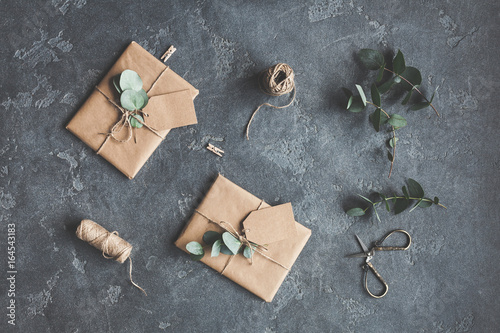 Gifts and eucalyptus branches on black background. Flat lay, top view
