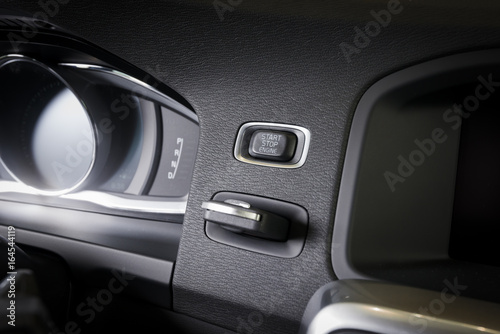 Engine start-stop button in a modern car interior © gargantiopa