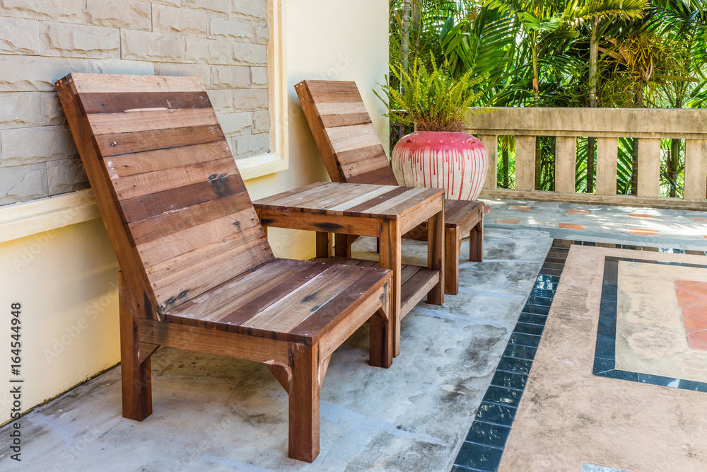 Natural wooden armchairs on patio for relaxation. They are made of wood lumber.