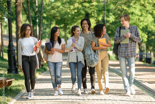 Happy young students walking outdoors photo