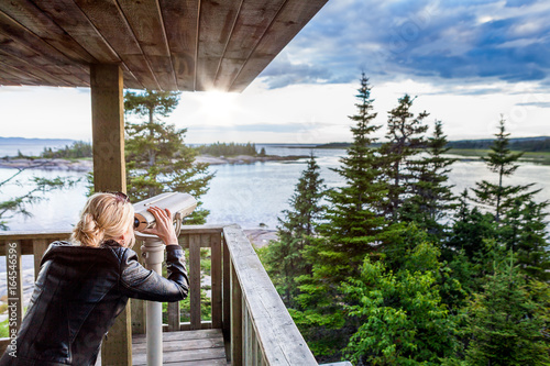 Young Woman Looking at the Amazing Nature Through a Binocular in a Observation Tower
