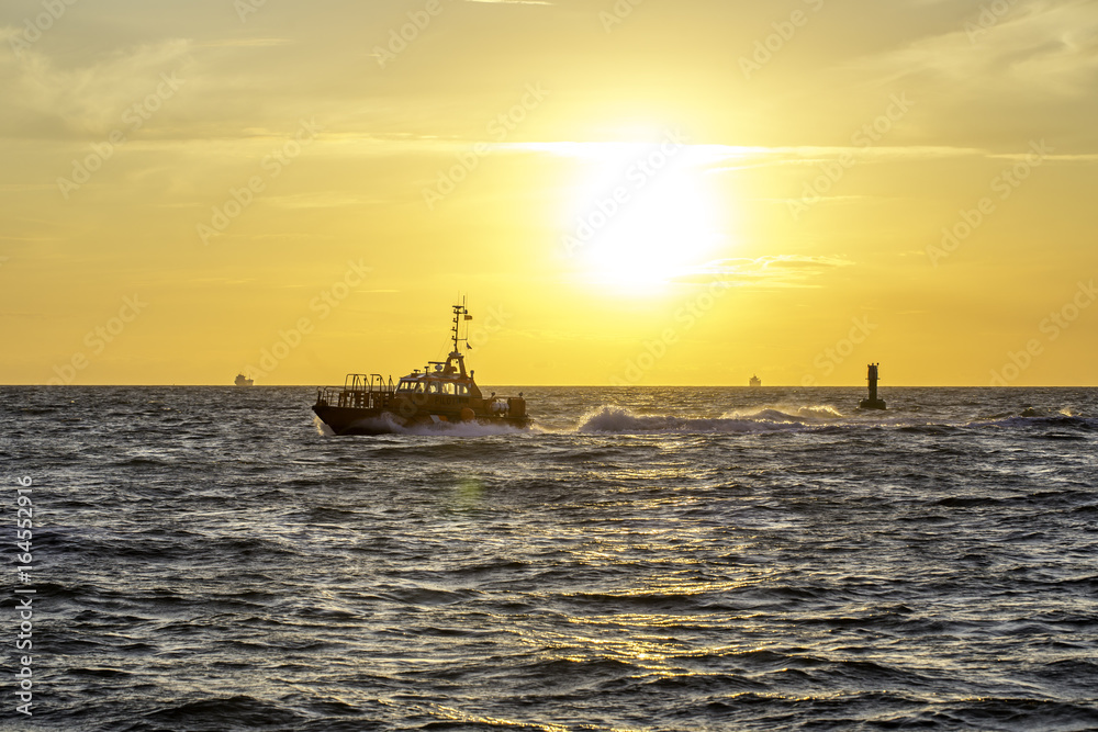 Motorboot im Sonnenuntergang am Hafen von Warnemünde an der Ostsee