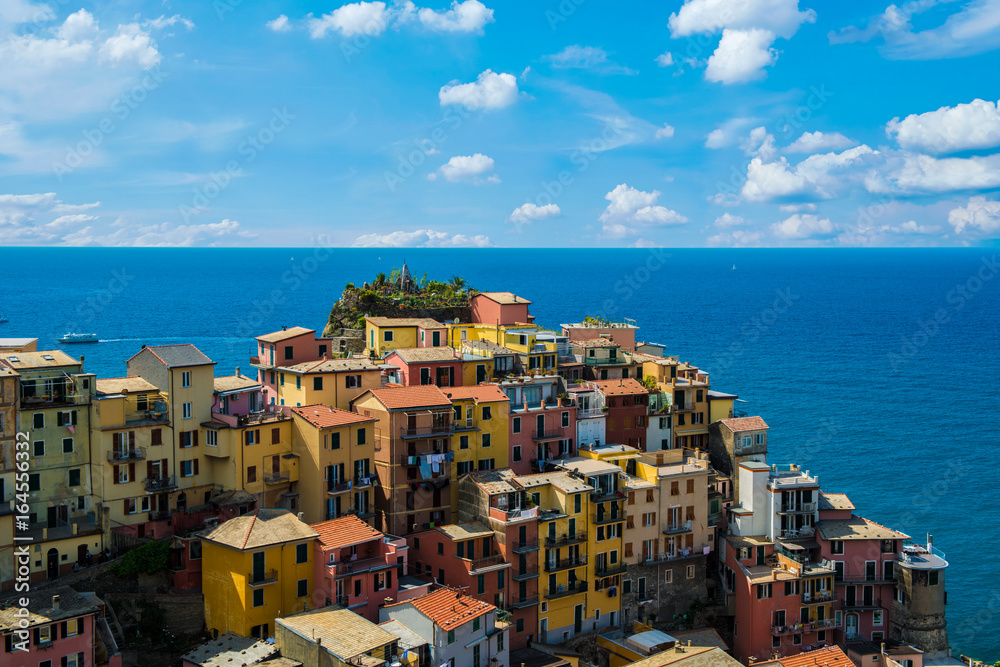 view of famous travel landmark destination Manarola colorful houses and nature, small mediterranean old sea town with harbour coast,Cinque terre National Park, Liguria, Italy. Summer sunny morning