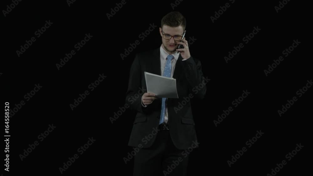 Happy corporate worker speaks on the cellphone and throws the papers up