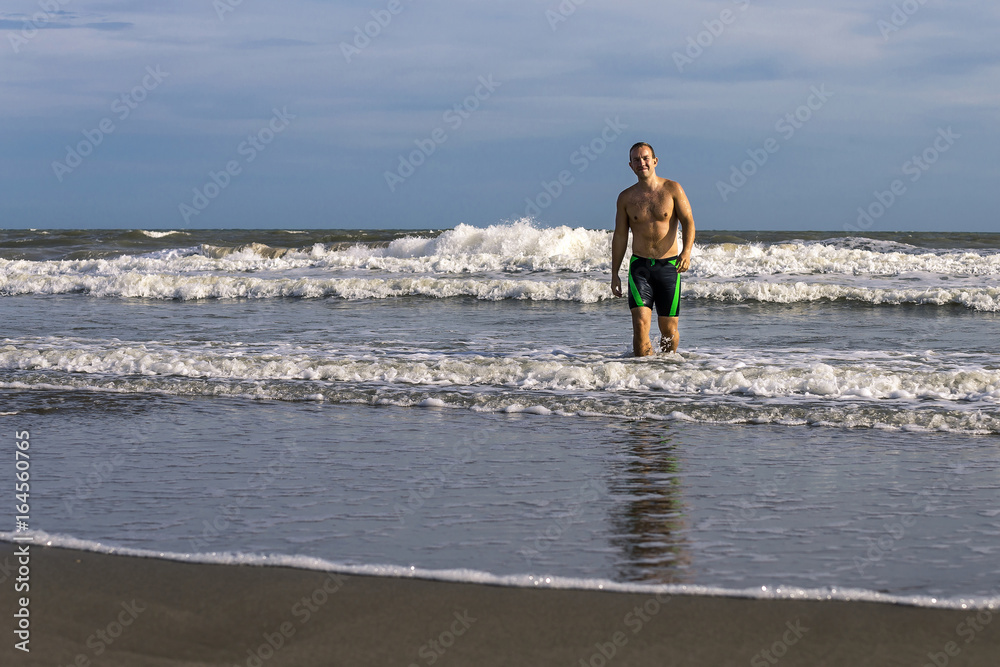 Portrait of young and attractive man on the beach of France.