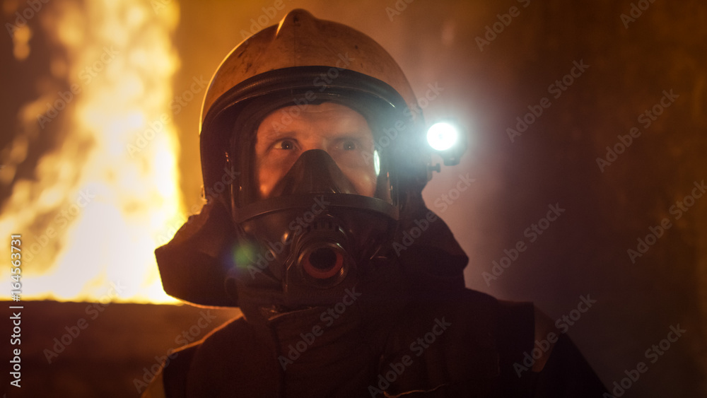Portrait of a Brave Firefighter Standing in a Burning Building. Raging Fire in the Background. Portrait of a Brave Firefighter Standing in a Burning Building. Raging Fire in the Background.