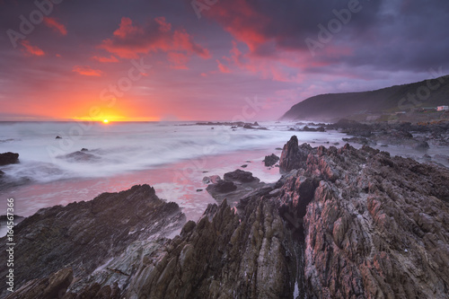 Sunset over the ocean in Garden Route NP, South Africa photo