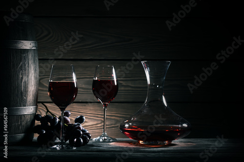 Decanter, two glasses of red wine and wooden barrel
