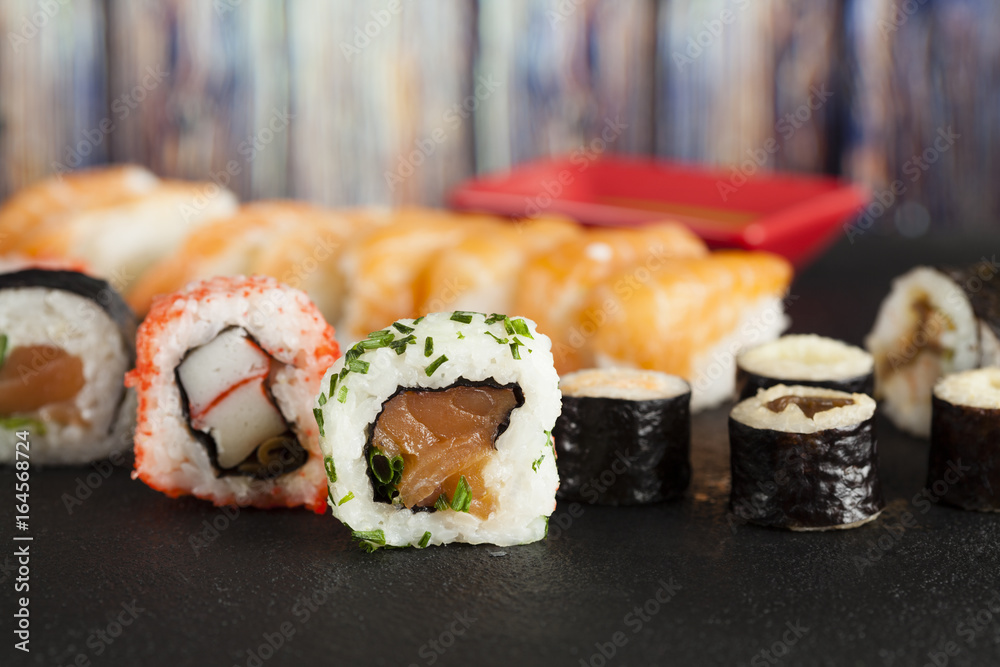 Japanese sushi on black and wooden background Japanese sushi on black and wooden background
