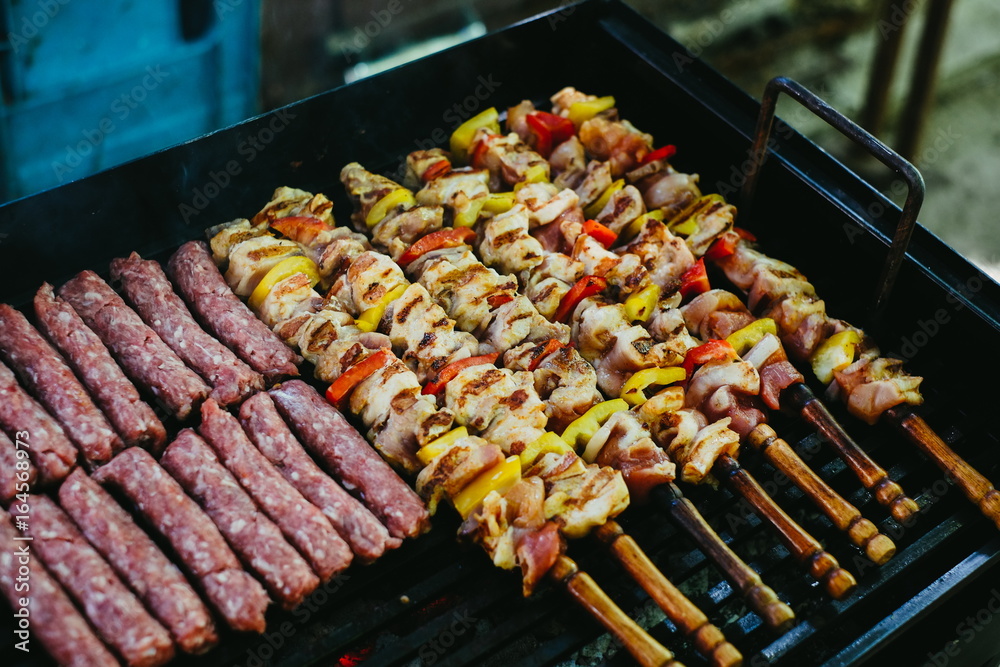 Grilling chicken meat skewers and kebab with vegetables on barbecue charcoal grill
