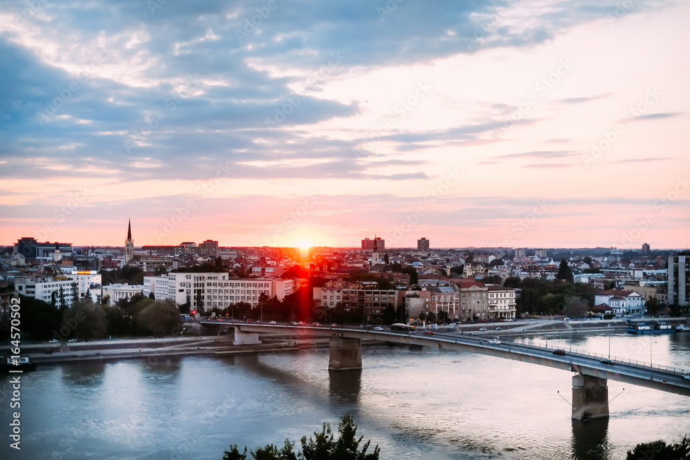 Beautiful sunset over Danube river and Novi Sad City with rainbow bridge